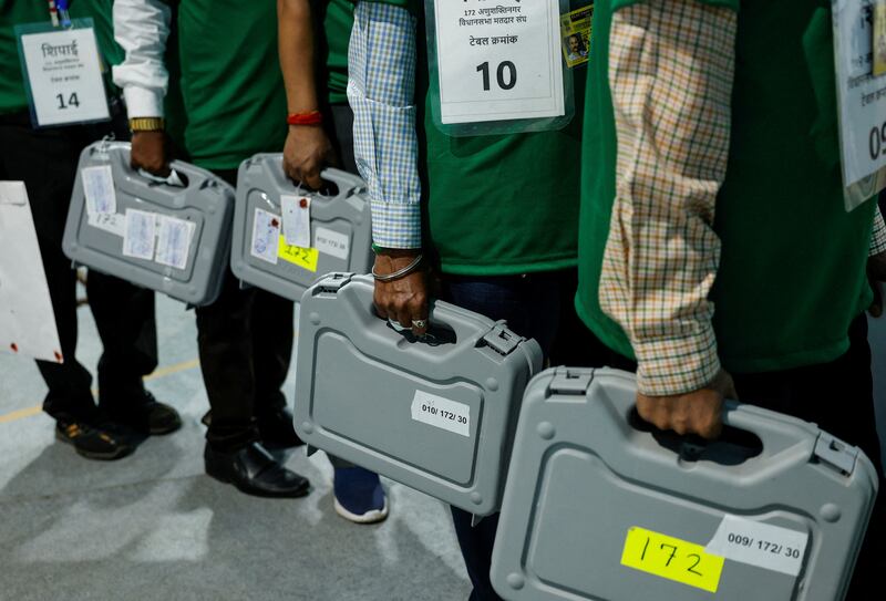 Electoral officers hold sealed electronic voting machines inside a vote-counting centre in Mumbai. Reuters