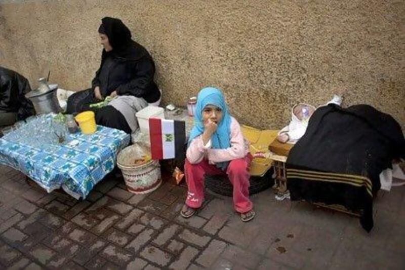 An Egyptian woman with her daughters waits for customers at her tea stall in a street of Cairo, Egypt, Saturday, Feb. 12, 2011. Egypt exploded with joy, tears, and relief after pro-democracy protesters brought down President Hosni Mubarak with a momentous march on his palaces and state TV. Mubarak, who until the end seemed unable to grasp the depth of resentment over his three decades of authoritarian rule, finally resigned Friday and handed power to the military. (AP Photo/Emilio Morenatti) *** Local Caption *** JEM108_Mideast_Egypt_.jpg