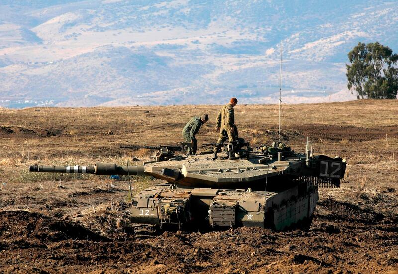 TOPSHOT - Israeli soldiers and armoured vehicles are pictured on November 19, 2019 near the border with Syria in the annexed Golan Heights. Israel's anti-missile defence system intercepted four rockets fired from neighbouring Syria on Tuesday, the army said. "Four launches were identified from Syria towards Israeli territory which were intercepted by the Israeli air defense systems," the Israeli army said in a statement.
 / AFP / JALAA MAREY
