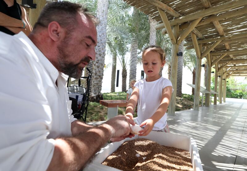 Crocodile specialist Gansuana shows young visitor Elsie a crocodile egg