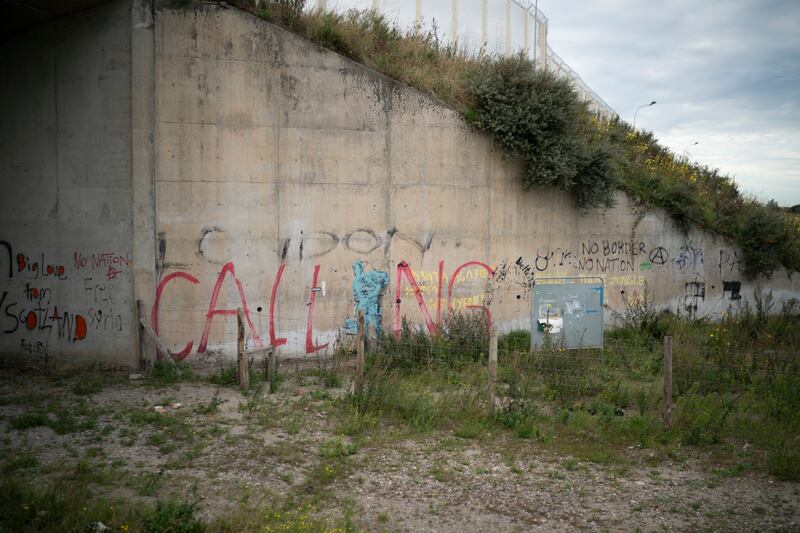 A Banksy mural at the entrance to the 'Jungle' migrant camp in Calais, France, fades as nature reclaims the area in 2018,  two years after more than 1,000 migrants were evicted. All photos: Getty Images