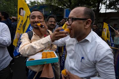 Supporters of the Aam Aadmi Party offer sweets to each other as they wait for the release of the party leader Arvind Kejriwal from Tihar Jail in New Delhi, India, Friday, May 10, 2024. (AP)