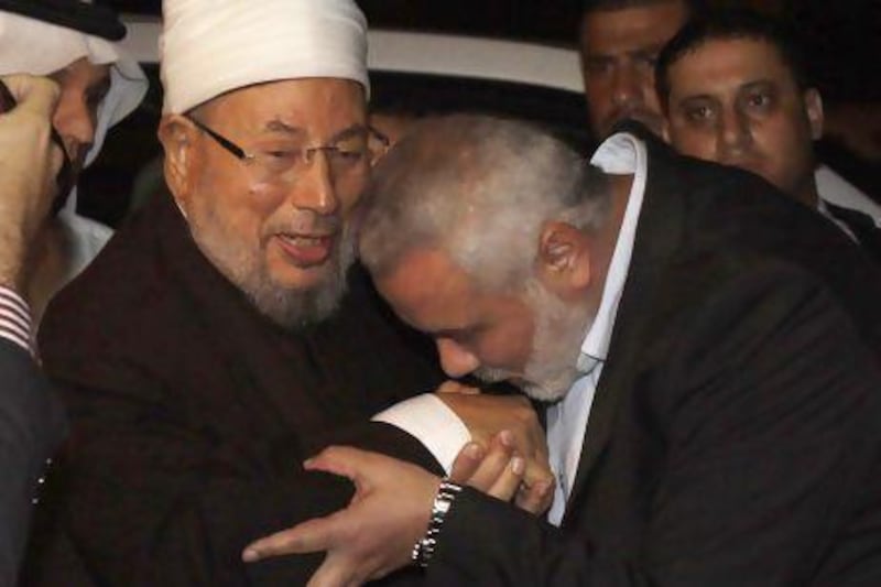 Hamas prime minister Ismail Haniyeh kisses the hand of Egyptian cleric and chairman of the International Union of Muslim Scholars, Sheikh Youssef Al Qaradawi.