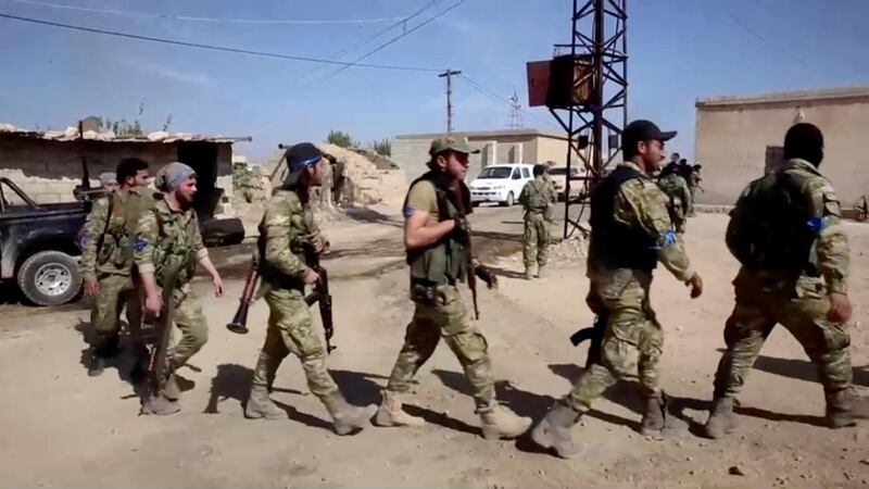 A group of Turkey-backed Syrian fighters prepares for offensive at a village near Turkish border in Yabisa, Syria in this still image taken from a video. Reuters