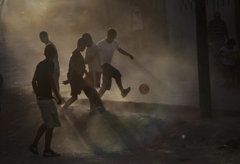 Residents play football at a dirt field in the Independencia impoverished neighbourhood in Monterrey. Daniel Becerril / Reuters