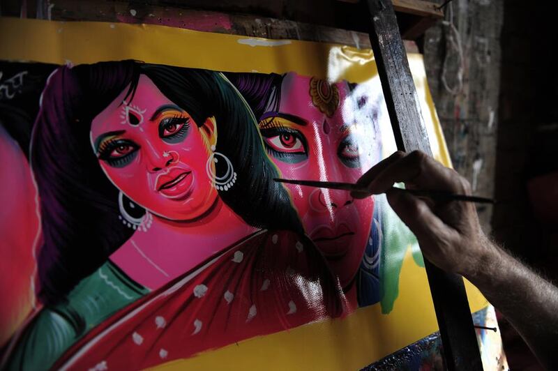 The Bangladeshi rickshaw artist R K Das paints a house in Dhaka, which is one of the settings for Maria Chaudhuri’s book Beloved Strangers. While there are some splashes of creative colour in Chaudhuri’s debut offering, it ultimately falls short, but does suggest future potential for the writer. AFP / Munir Uz Zaman