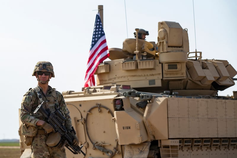 A US soldier stands next to an armoured vehicle near the Syrian town of Tal Hamison last week. AFP