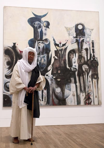 Sudanese artist Ibrahim El-Salahi poses for a photograph in front of his painting entitled "Reborn Sounds of Childhood Dreams" at the Tate Modern in London on July 1, 2013.  AFP PHOTO/JUSTIN TALLIS - “ RESTRICTED TO EDITORIAL USE, MANDATORY MENTION OF THE ARTIST UPON PUBLICATION, TO ILLUSTRATE THE EVENT AS SPECIFIED IN THE CAPTION ” (Photo by JUSTIN TALLIS / AFP)