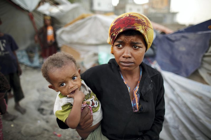 A woman from the Akhdam community holds her son in a slum area in Yemen's southwestern city of Taiz October 11, 2012. Yemeni Akhdam, or servants, are similar to hereditary castes, but are distinguished by their African features and the menial jobs they perform. Widespread prejudice places the Akhdam at the bottom of Yemen's social ladder. Asked about the origins of the Akhdam, Yemenis say they are descendants of Ethiopians who crossed the Red Sea to conquer Yemen before the arrival of Islam some 1,400 years ago - making them outsiders in their own country. Most live in slum areas in the outskirts of the capital Sanaa and other main cities. They reside in small huts haphazardly built of wood and cloth, without basic services such as running water, electricity and sewage networks. Picture taken October 11, 2012. REUTERS/Khaled Abdullah (YEMEN - Tags: SOCIETY POVERTY)

ATTENTION EDITORS: PICTURE 12 OF 20 FOR PACKAGE 'YEMEN'S UNDERCLASS'
SEARCH 'AKHDAM' FOR ALL IMAGES