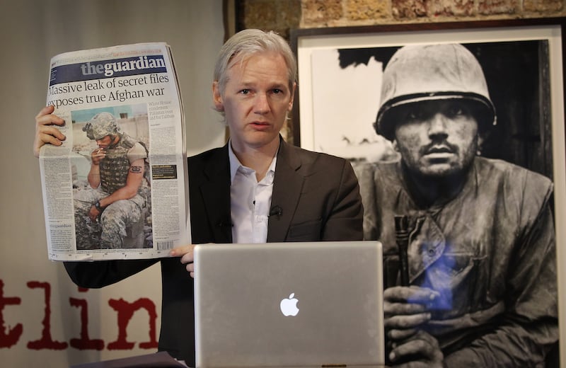 He holds up a copy of 'The Guardian' newspaper in London in July 2010, after WikiLeaks published 90,000 secret US military records. Getty Images