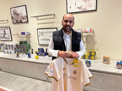 Al Nassr fan Thamer Al Wajaan buys the team's second jersey at the club shop to have Ronaldo's No 7 added to it. 