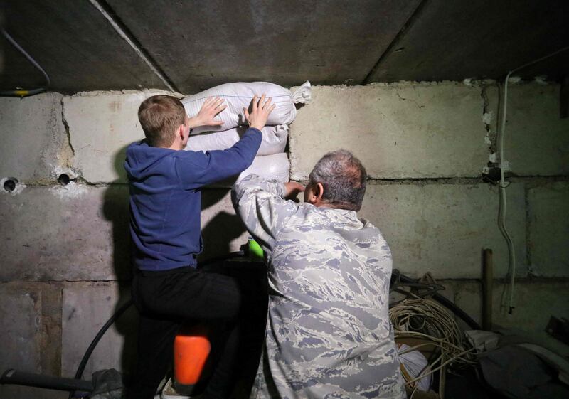 A Ukrainian teenager helps a church minister reinforce basements in a centre for children in the Ukrainian village of Chervone. AFP