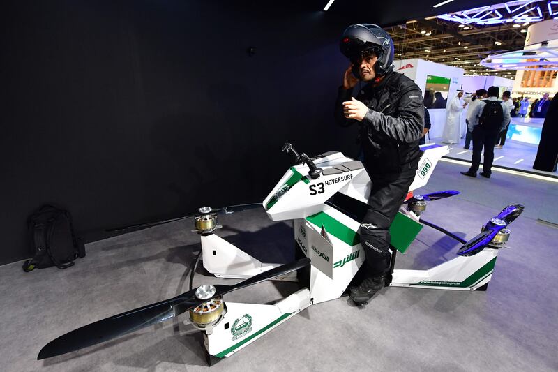 An Emiratee police officer stands next to a drone motorcycle at the Gitex 2017 exhibition at the Dubai World Trade Center in Dubai on October 8, 2017.  / AFP PHOTO / GIUSEPPE CACACE
