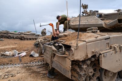 Israeli soldiers work on their vehicle on Monday during the four-day truce near the border of Gaza. Getty Images