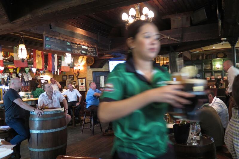 A waitress serves customers at a restaurant in Dubai, before the coronavirus outbreak hit. Dubai and Abu Dhabi have overhauled their alcohol licensing system this year to help residents and tourists ensure they stay on the right side of the law. Kamran Jebreili / AP