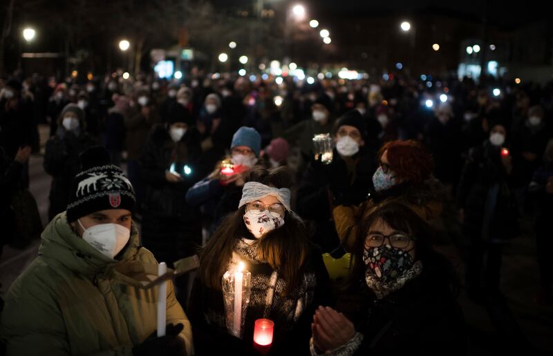 Protesters in the Austrian capital of Vienna carry candles in memory of those who have died of coronavirus. AP Photo