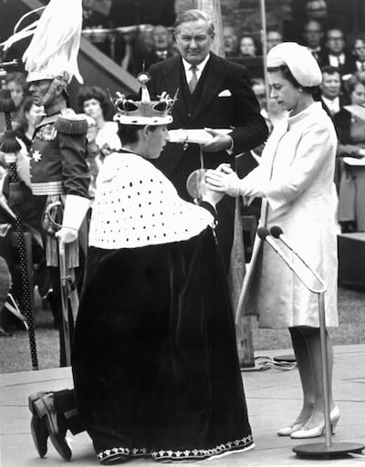 Britain's Queen Elizabeth II (R) holds the hands of her 20-year-old son Prince Charles (L) during his investiture as Prince of Wales, 11 July 1969, at Caernarfon castle (Walles). Britain's Prince Charles turns 70 on November 14, 2018 as busy as ever, having spent a lifetime forging his own path during his record wait for the throne. / AFP / -
