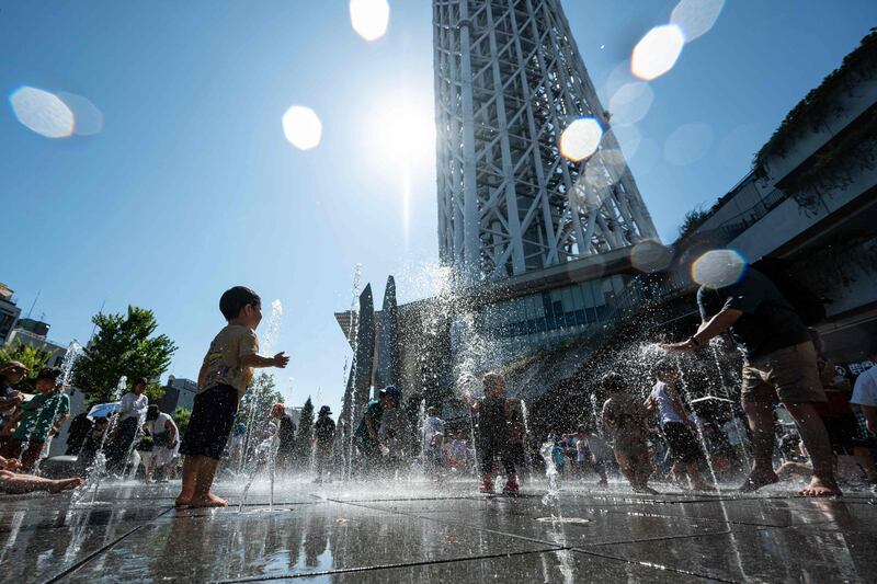 Children cool off outside the Tokyo Skytree as temperatures hit the mid-30s. Japan issued heatstroke alerts to tens of millions of people on Sunday. AFP