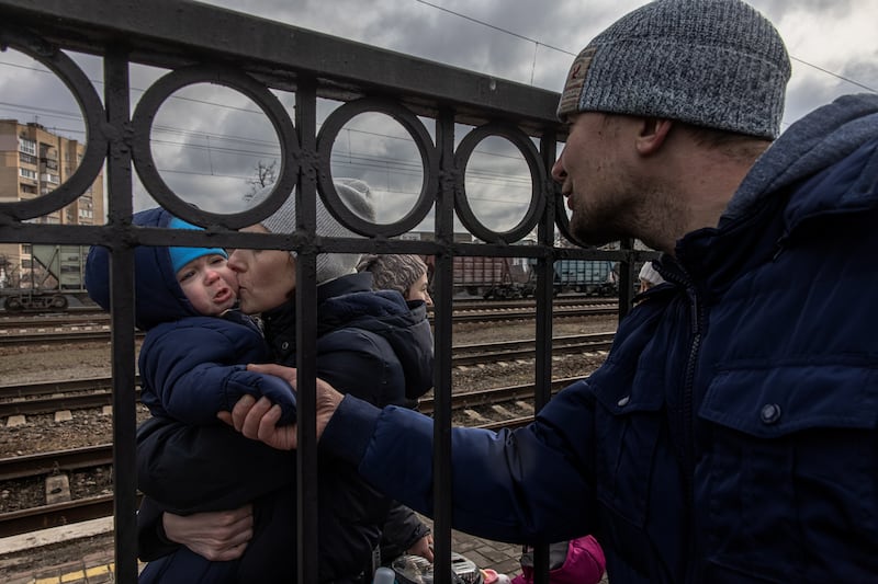 Ukrainian Oleg, who decided to remain in Irpin, comforts his son, Maksim, and his wife, Yana, before the arrival of an evacuation train to the city of Kyiv. EPA