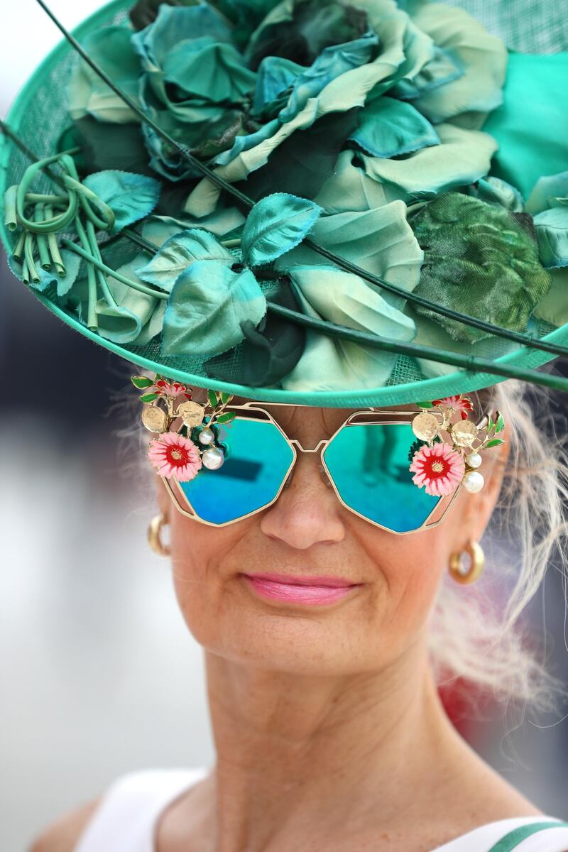 A fan looks on in her funky sunglasses and bright green hat during the Dubai World Cup at Meydan Racecourse. Getty Images