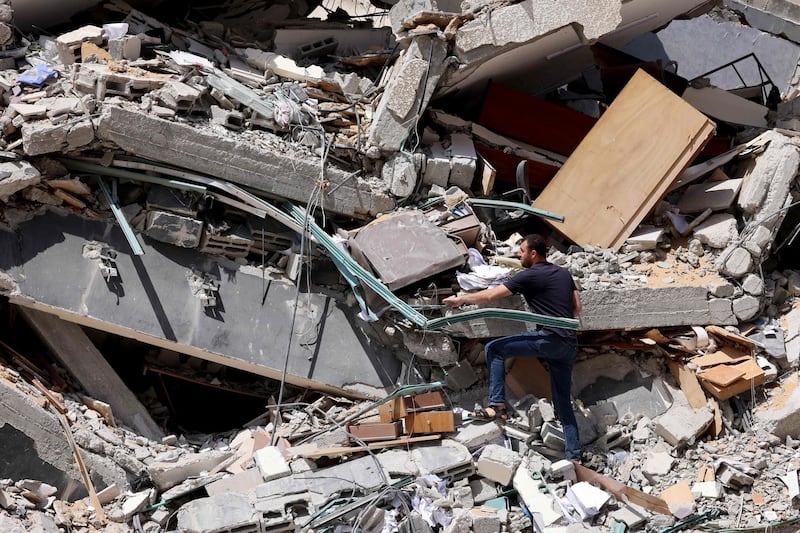 A Palestinian man sifts through the debris of the Al Jalaa tower, which housed media organisations and was destroyed by Israeli air strikes in Gaza city. AFP