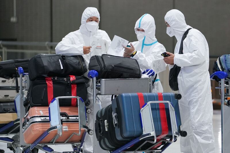 Travellers wearing personal protective equipment line up at China Eastern Airlines. Bloomberg