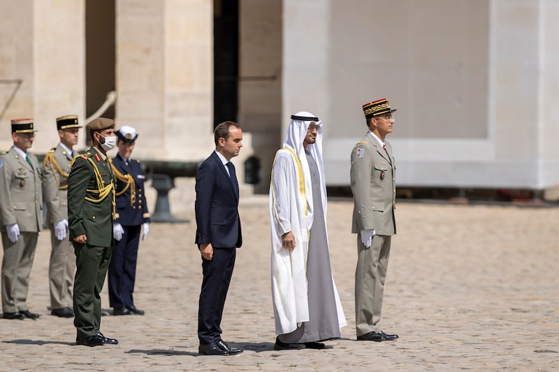 Sheikh Mohamed and Mr Lecornu stand for the French national anthem during the official reception. Photo: Presidential Court