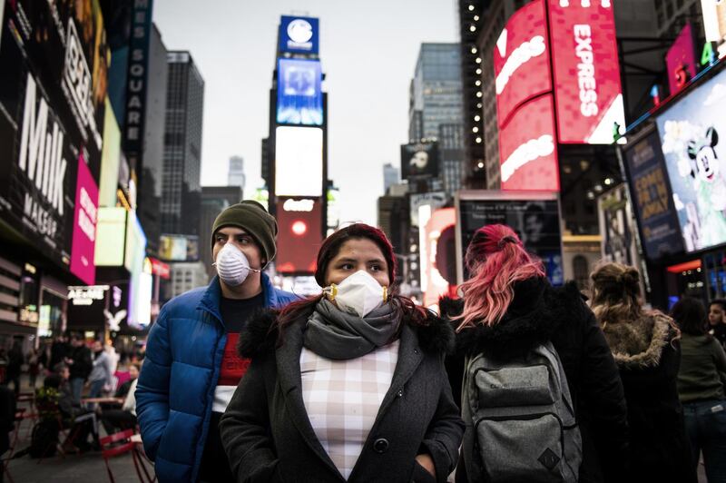 Pedestrians wearing protective masks walk through Times Square, New York City. Bloomberg