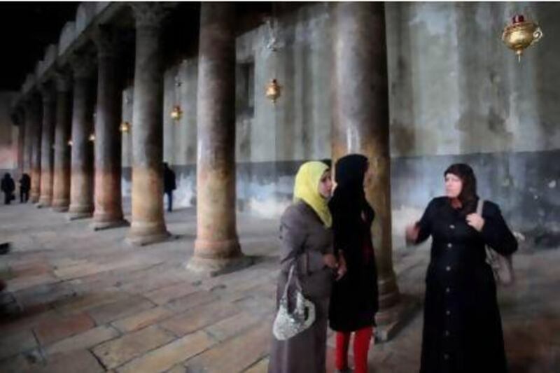 Muslim women stand in the Church of the Nativity in Bethlehem. Thousands more Palestinians and tourists have flocked to the birthplace of Jesus Christ to mark Christmas.