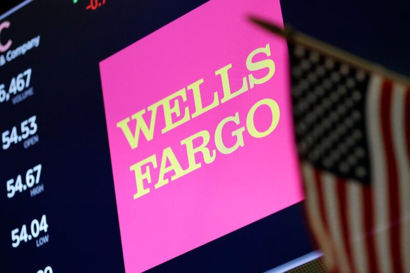 FILE- In this May 17, 2018 file photo, the logo for Wells Fargo appears above a trading post on the floor of the New York Stock Exchange. Wells Fargo is paying $575 million as part of deal to resolve investigations by every state into its banking practices, which have included creating phony accounts and using manipulative sales practices. The deal also includes creating teams to review and respond to customer issues about its banking and sales practices.  (AP Photo/Richard Drew, File)