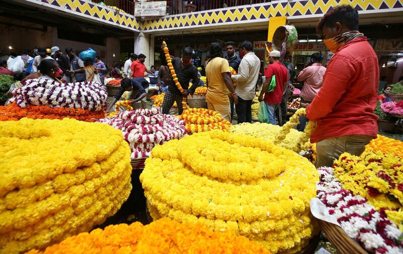 Vendors arrange flowers at a wholesale flower market ahead of the Hindu festival of Dussehra, in Bengaluru, India. Health officials have warned about the potential for the coronavirus to spread during the upcoming religious festival season marked by huge gatherings in temples and shopping districts. AP