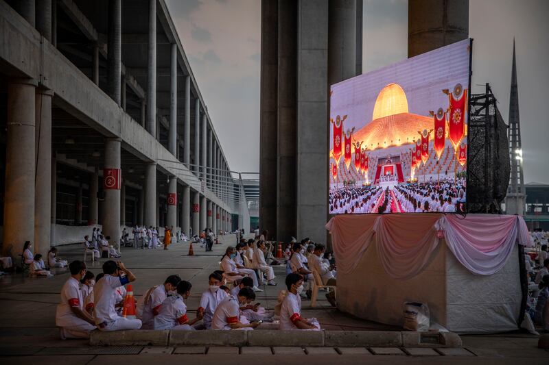 Devotees watch a live stream of a Makha Bucha Day ceremony at Wat Phra Dhammakaya temple. Getty