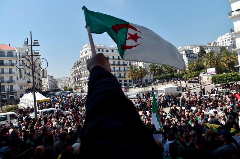Algerians wave the national flag in Algiers. AFP