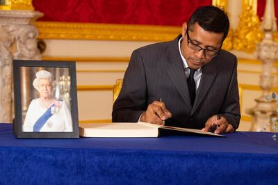 Daniel Mendez, husband of the Governor-General of Belize Dame Froyla Tzalam, signs a book of condolence to the late Queen Elizabeth at Lancaster House in London. AP