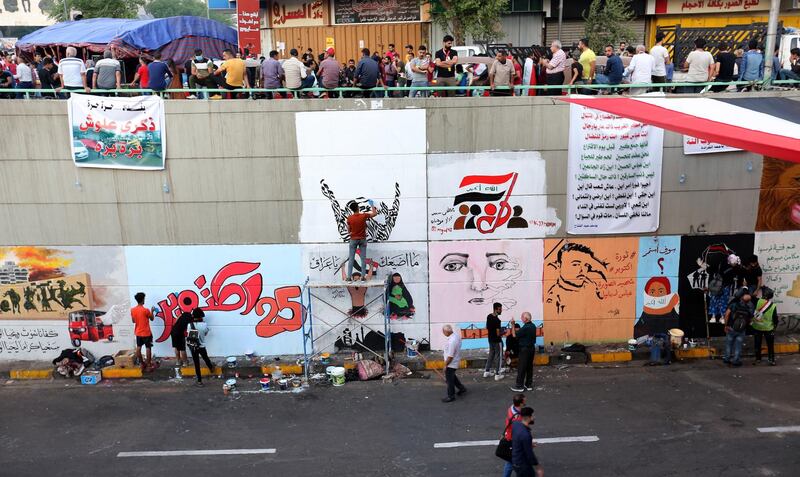 Iraqi protesters paint a wall with graffitis near Tahrir square in central Baghdad.  EPA