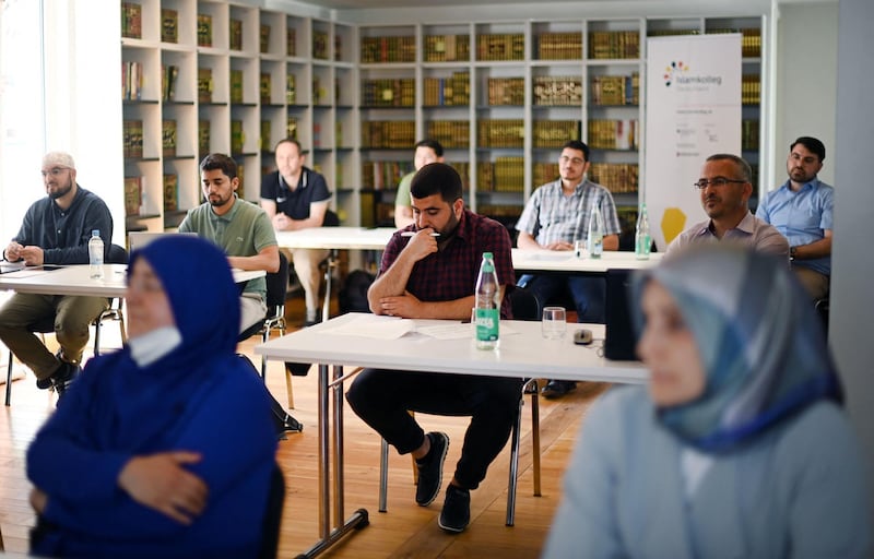 Students take part in a Qur'an recitation lesson at the Islamkolleg Deutschland in Osnabrueck, western Germany on June 14, 2021. The first block course started on June 14 for the 35 collegiate students. A good half of them will start with imam training, the other Muslim clerics want to continue their training in cooperation with a university in a practical manner and across associations. Teaching of sermons, Qur'an recitation, pastoral care and church pedagogy are among the subjects on the curriculum.  / AFP / Ina FASSBENDER
