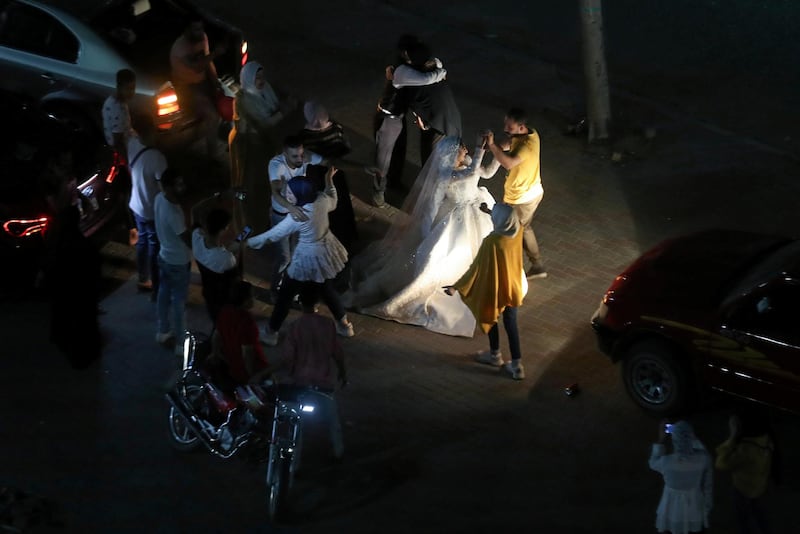 A bride and groom celebrate their wedding party with family on a street, as celebration halls are shut down amid concerns about the spread of the coronavirus disease (COVID-19), in Cairo, Egypt.  Reuters