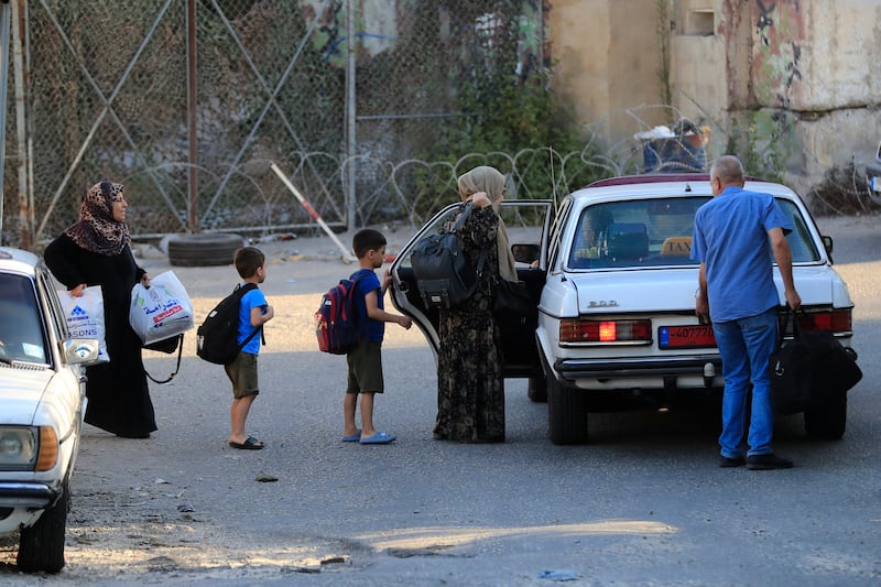 Residents of Ain Al Hilweh, Lebanon's largest camp for Palestinian refugees, flee their homes because of the fighting. AP