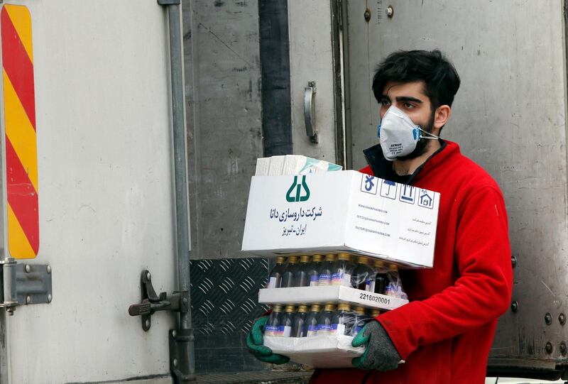 An Iranian worker carries medical supplies on a street of Tehran, Iran.  EPA