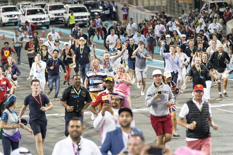 Abu Dhabi, United Arab Emirates, November 26, 2017:    Fans run on to the track after the Abu Dhabi Formula One Grand Prix at Yas Marina Circuit in Abu Dhabi on November 26, 2017. Christopher Pike / The National

Reporter: John McAuley, Graham Caygill
Section: Sport