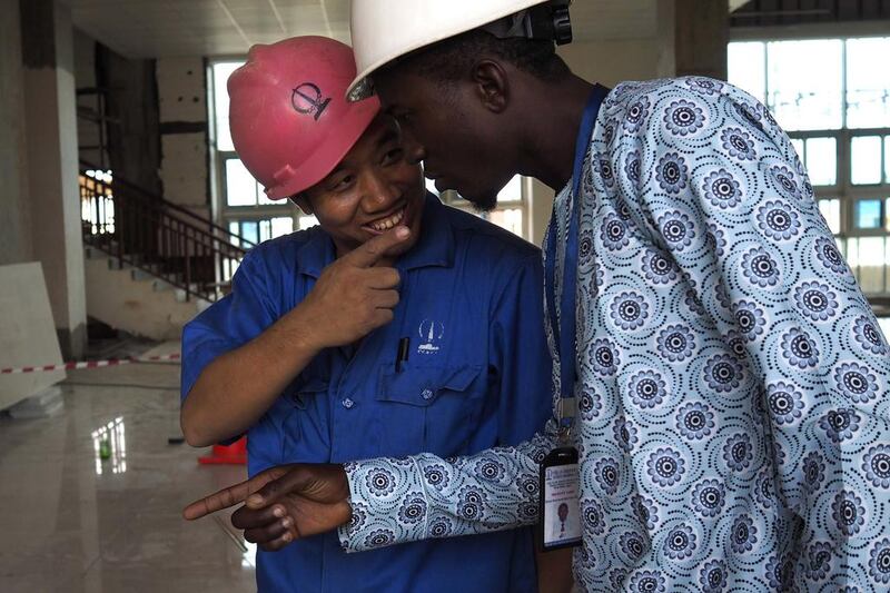 A Chinese worker jokes with his Nigerian counterpart at the National Arts Theatre stop of the light rail system under construction in Lagos, Nigeria. Joe Penney / Reuters