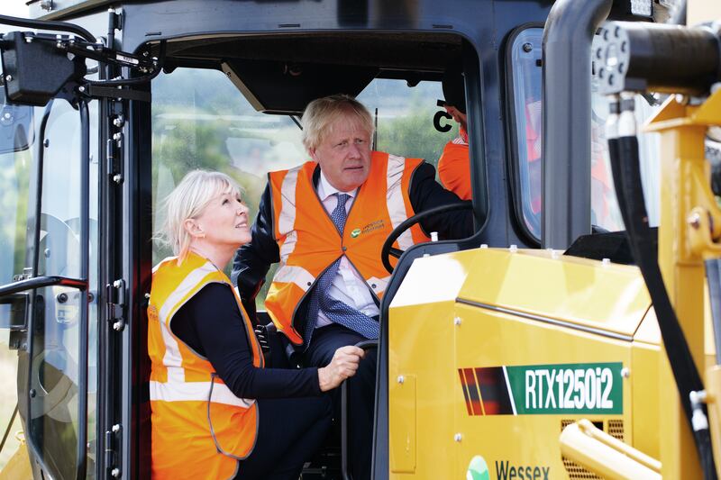 Mr Johnson and Ms Dorries sit in the cabin of the plough. PA