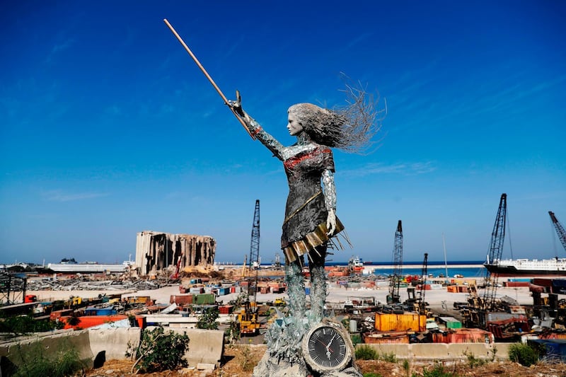 A statue of a woman made out of glass and rubble that resulted from the Beirut port mega explosion August 04, is placed opposite to the site of the blast in the Lebanese capital's harbour to mark the one year anniversary of the beginning of the anti-government protest movement across the country on October 20, 2020. Hundreds marched in Beirut on the weekend to mark the first anniversary of a non-sectarian protest movement that has rocked the political elite but has yet to achieve its goal of sweeping reform. A whirlwind of hope and despair has gripped the country in the year since protests began, as an economic crisis and a devastating port explosion two months ago pushed Lebanon deeper into decay.
 / AFP / JOSEPH EID
