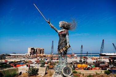 A statue of a woman made out of glass and rubble that resulted from the Beirut port mega explosion August 4, is placed opposite to the site of the blast. AFP