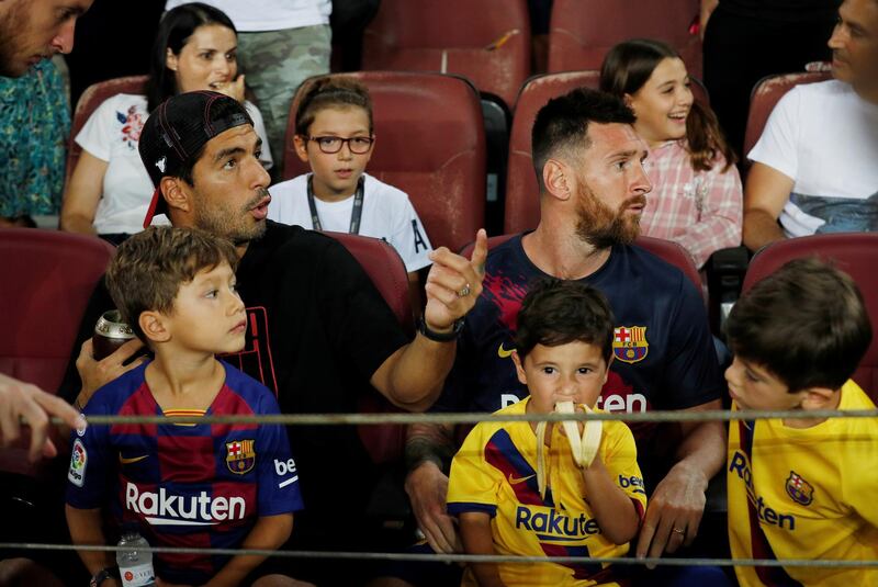 Barcelona's Luis Suarez and Lionel Messi watch the match from the stands. Reuters