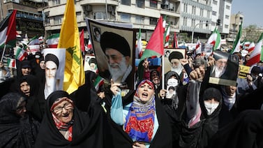 Women wave Iranian and Palestinian flags during an anti-Israel rally in Tehran on Friday. EPA