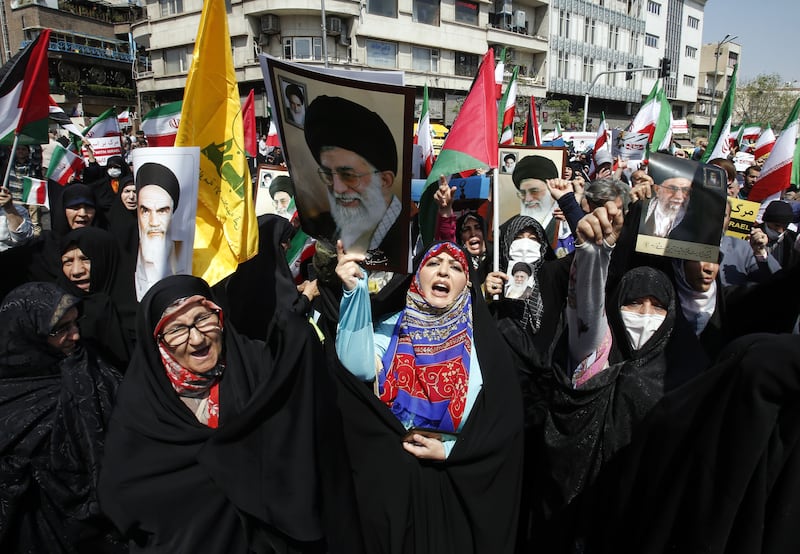 Women wave Iranian and Palestinian flags during an anti-Israel rally in Tehran on Friday. EPA
