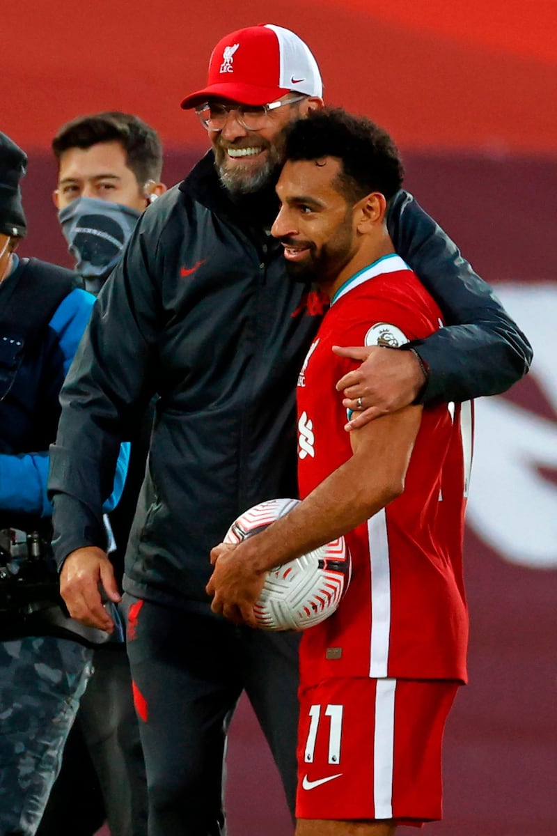 Liverpool's Egyptian midfielder Mohamed Salah takes the match ball as he is greeted by manager Jurgen Klopp. AFP