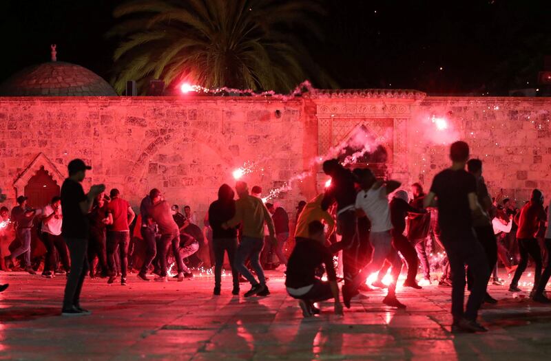 Palestinians react as Israeli police fire stun grenades during clashes. Reuters