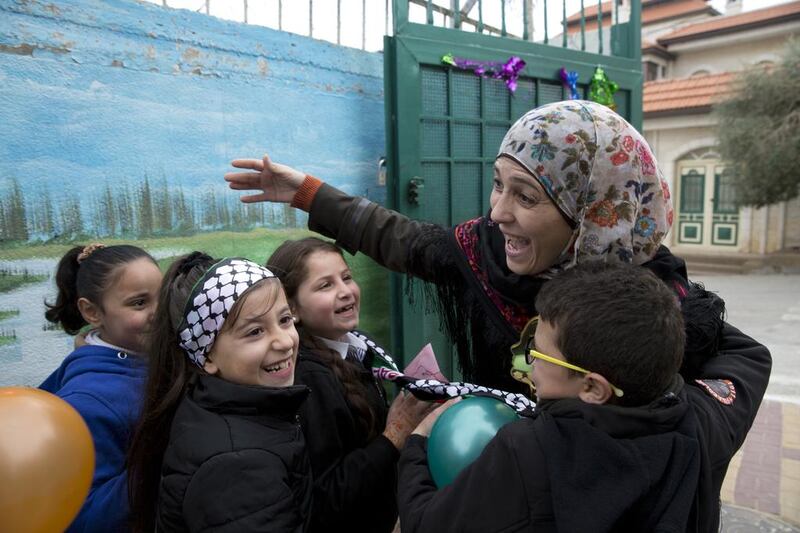 Grade 2 students greet Palestinian teacher Hanan Al Hroub, winner of the Global Teacher Prize, upon her return to Samiha Khalil school in Al Bireh, just outside Ramallah, on March 20, 2016. Ms Al Hroub uses a teaching technique she developed, called “Play and Learn”, which promotes peace and non-violence. Heidi Levine for The National